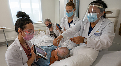 nurse practitioner students with faculty in telehealth simulation